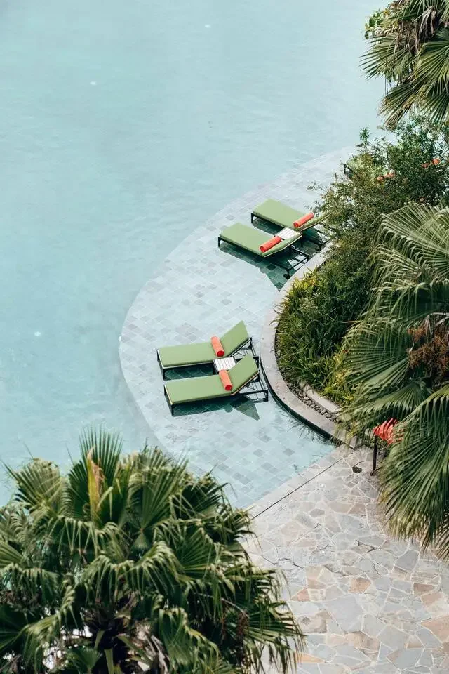 Piscine avec transats, un moment de détente lors d’un voyage en Thaïlande